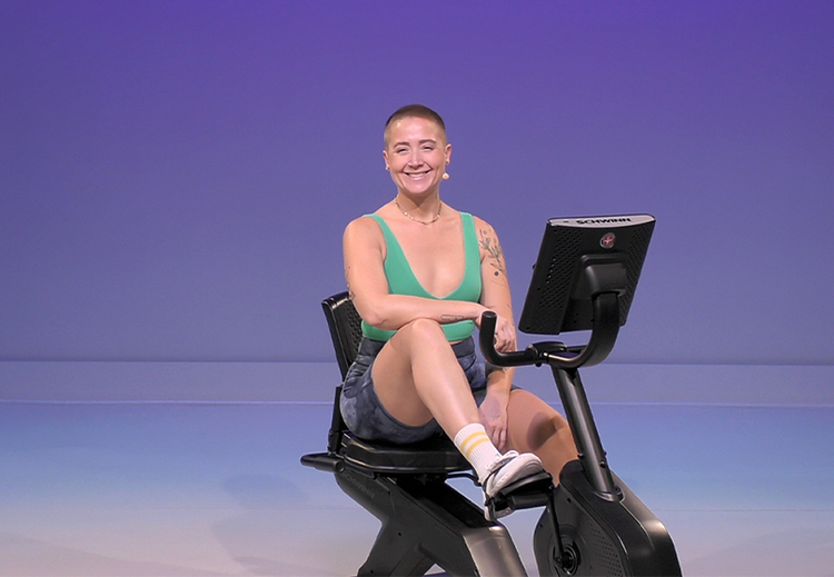 Person using a Schwinn recumbent bike against a blue gradient background.