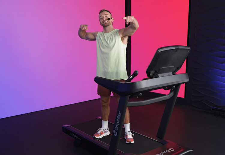 Person using a treadmill with a colorful gradient background.