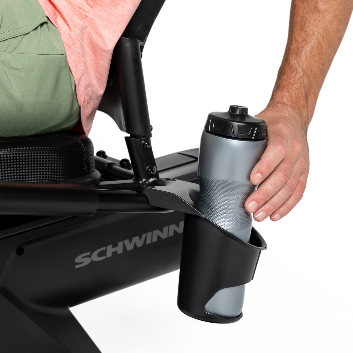 Hand holding a water bottle placed in holder on the Schwinn 590R Recumbent Bike.