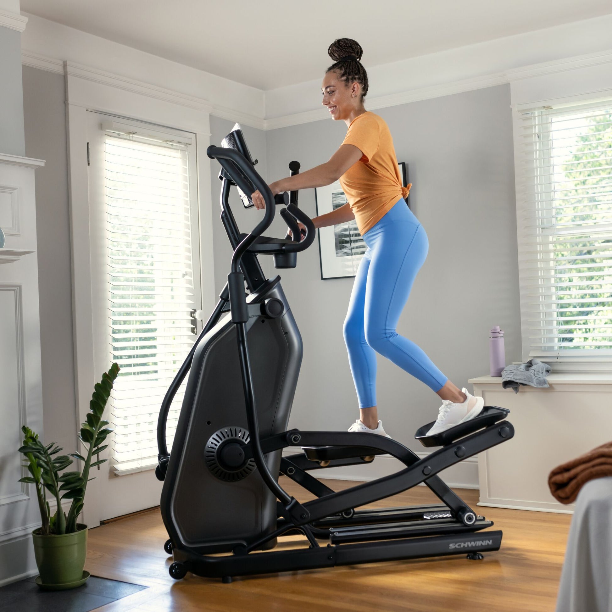 Woman using the Schwinn 590E Elliptical in a home setting.