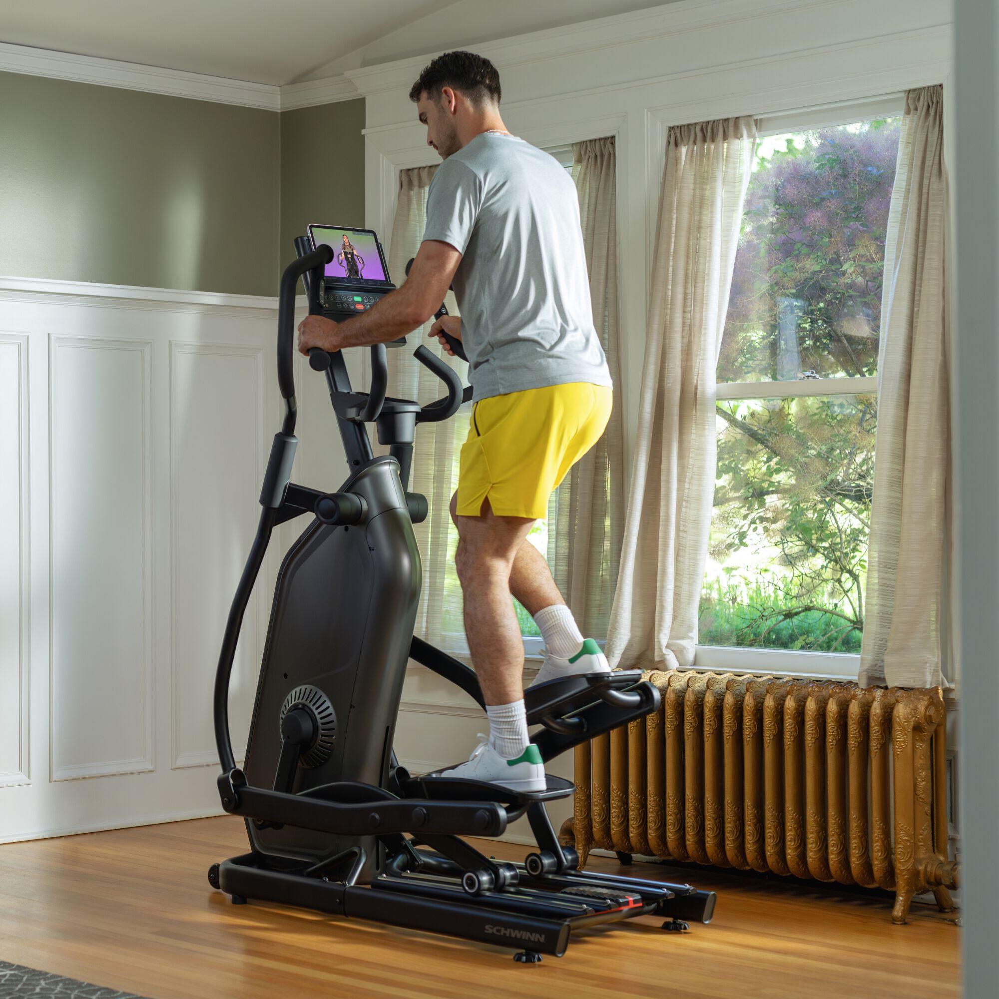 Man using the Schwinn 590E Elliptical in a home setting.