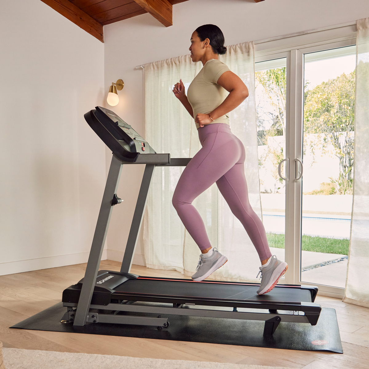 Person running on the Schwinn SFT3.1 Treadmill in a home setting.