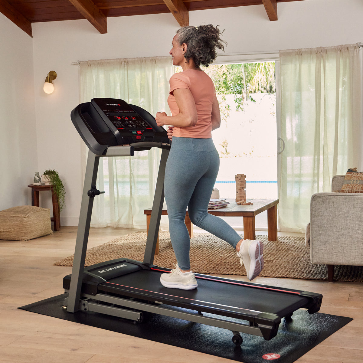 Frau benutzt Schwinn SFT3.5 Laufband im Wohnzimmer.